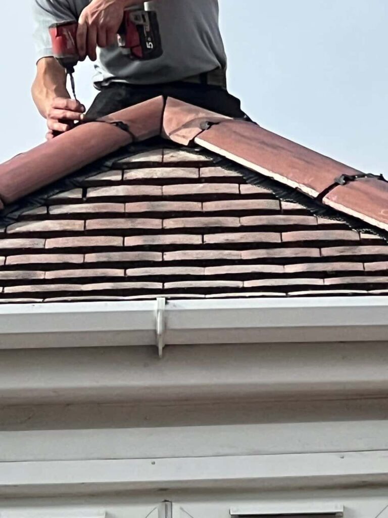 This is a photo of one of the operatives of Ripley Roofing Repairs installing new ridge tiles